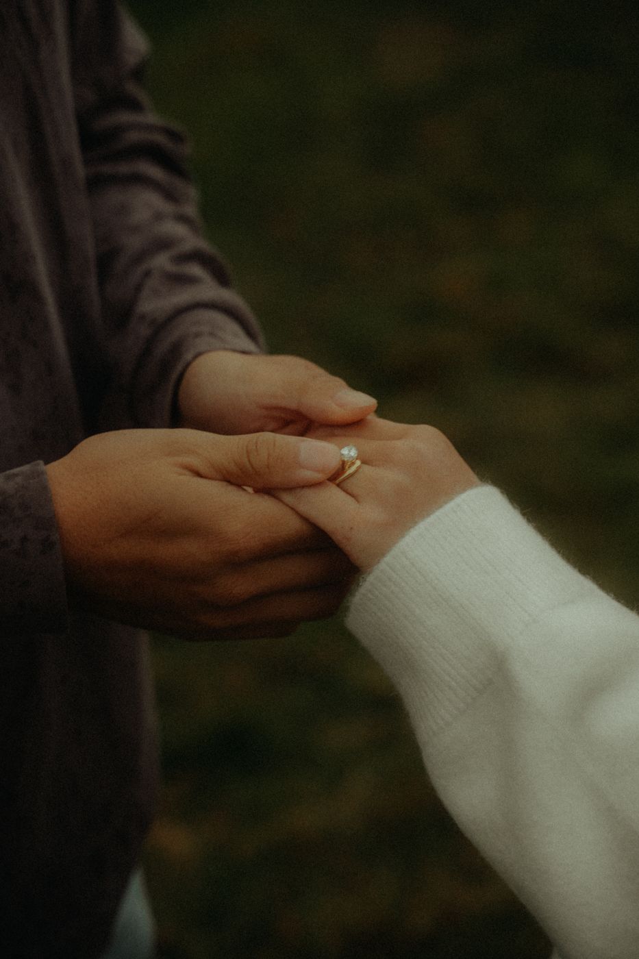 Eddison holding Clarissa's hand, her engagement ring catching the light